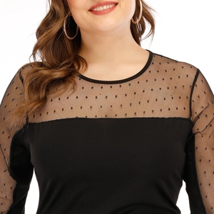 Détail de maille transparente à motif plumetis sur une robe noire moulante élégante