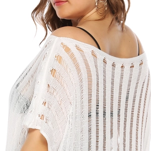 Detail of white crochet knit beach cover-up showing intricate mesh texture and off-shoulder cut