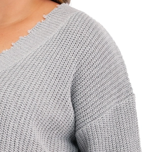 Close-up of V-neck knitted sweater featuring unique distressed ripped edge details