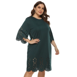 Detail of laser-cut hollow patterns on the sleeve and hem of a dark green plus-size dress