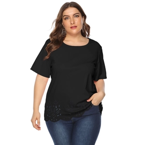 Detail of laser-cut eyelet embroidery on the hem of a plus-size black short-sleeve T-shirt