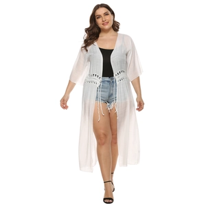 Detail of white semi-transparent long cardigan with crochet lace waist and fringe tassels