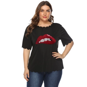 Dettaglio delle labbra di paillettes rosse e bordi ondulati su t-shirt nera taglie forti