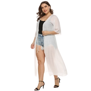 Detail of white semi-transparent long cardigan with tassel ties and subtle ribbed texture