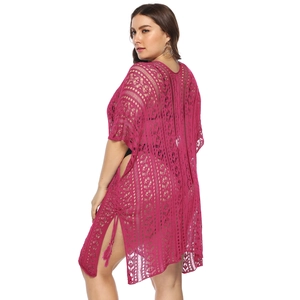 Detail of fuchsia crochet beach cover-up featuring hollow-out patterns and side slit tassels