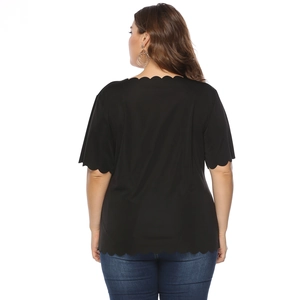 Detail view of the black short sleeve top featuring unique scalloped edges and elastic fabric