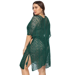 Detail of forest green crochet lace beach cover-up featuring fringe and side slits