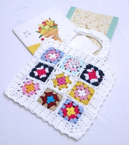 Détail d'un sac à main fait main au crochet avec carrés multicolores et perles blanches