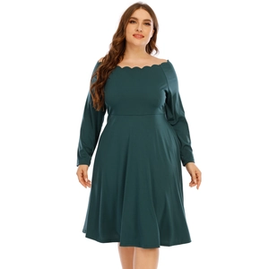 Dettaglio dello scollo ondulato a spalle scoperte e del tessuto verde scuro del vestito