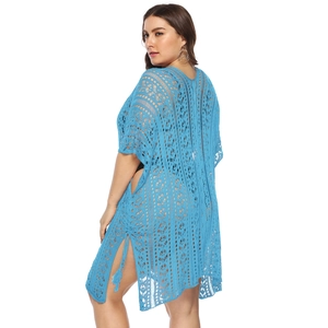 Detail of light blue crochet beach cover-up showing geometric hollow-out knit texture