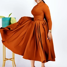 Deep orange long sleeve high neck maxi dress with oversized pleated dramatic skirt silhouette