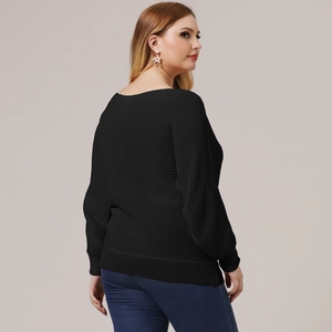 Detail of the knit texture and ribbed hem on this loose black plus size long sleeve top