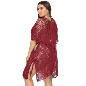 Detail view of burgundy crochet cover-up showing hollow lace texture and side slit with tassels