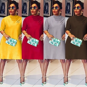 Detail of pleated short-sleeve mini dress featuring a floral brooch in four solid colors