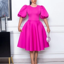 Détail de la robe trapèze rose vif avec manches bouffantes et taille plissée ajustée