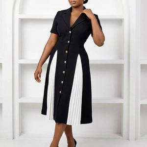 Détail d'une robe noire à manches courtes avec d'élégants panneaux plissés blancs latéraux