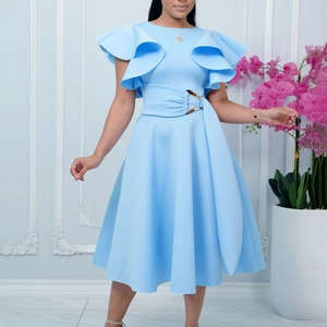 Detail of elegant light blue dress showing ruffled sleeves and waist belt with golden buckle