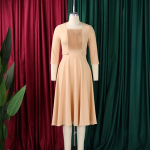 Detail view of square neckline and pleated bodice on an apricot high waist dress