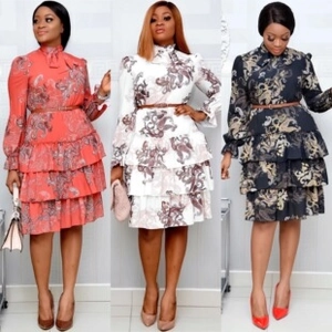 Trio view of boho floral tiered dresses in orange, white, and black with waist belts