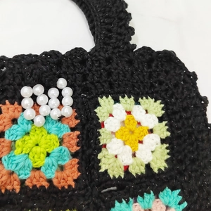 Détail d'un sac au crochet fait main avec motifs floraux et perles décoratives