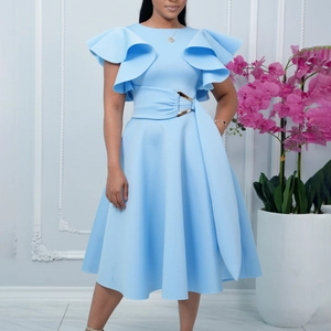 Detail of light blue dress showing ruffled sleeves and a gold buckle belted waistline
