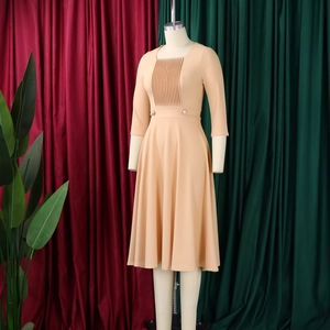 Detail of square neckline and pleated bodice on apricot high-waist A-line dress