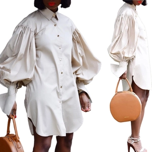 Detail of oversized puff sleeves and button-down front on a beige shirt dress