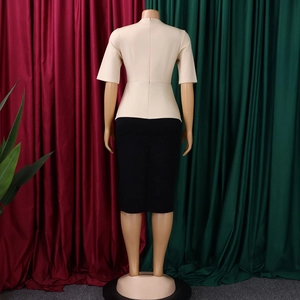 Détail du dos d'un haut beige à col rond et d'une jupe crayon noire sur un mannequin de couture