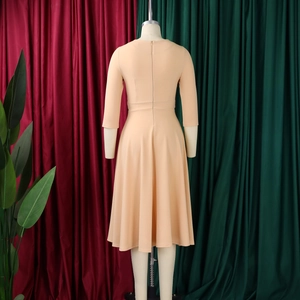Detail view of the back of a beige square neck dress featuring tailored high waist stitching