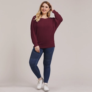 Women's oversized burgundy knit sweater with batwing sleeves and skinny jeans outfit