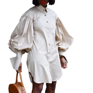 Detail of oversized puff sleeves and long cuffs on this beige cotton shirt dress