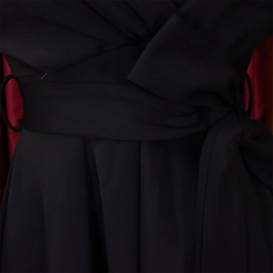 Detail of waist tie on a black V-neck dress with contrasting red lining and fine stitching