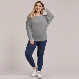Women's plus size grey knit crewneck sweater with blue skinny jeans and sneakers
