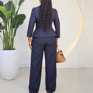 Vue arrière du blazer bleu marine à basque et du pantalon large dans un studio moderne