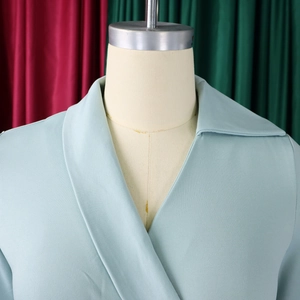 Détail du revers en V sur une robe cintrée bleu menthe, vue rapprochée sur mannequin