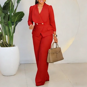 Détail du blazer rouge à boutons dorés et pantalon large assorti sur mannequin
