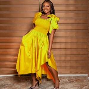 Elegant sleeveless bright yellow dress with large shoulder bow and irregular hemline