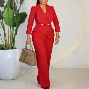 Détail d'un blazer rouge à revers avec boutons dorés sur une combinaison ajustée