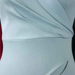 Détail de la robe crayon vert menthe avec plis croisés et texture sergé élégante