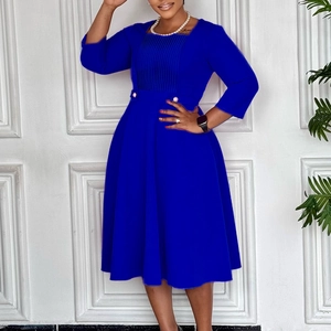 Detail of royal blue dress featuring square neckline with vertical pleats and pearl buttons