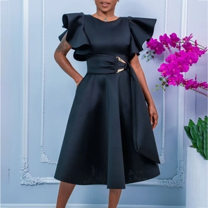 Detailed close-up of a black A-line dress featuring ruffle sleeves and a belt with gold buckle