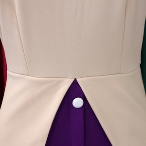 Détail de la taille d'une robe bicolore beige et violette avec bouton blanc