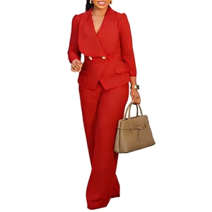 Détail du blazer rouge avec boutons dorés croisés et pantalon large assorti