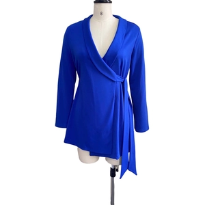 Detail of royal blue wrap-style long sleeve top with notch lapel and side tie closure