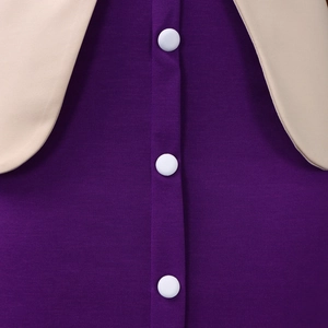 Détail de la robe élégante violette montrant le col rond et les boutons blancs cousus