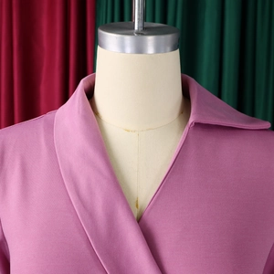 Détail du col en V rose et de la texture en maille de qualité sur la robe crayon