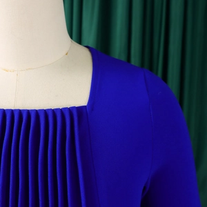 Detail of square neckline and pleated texture on a high-waisted blue dress