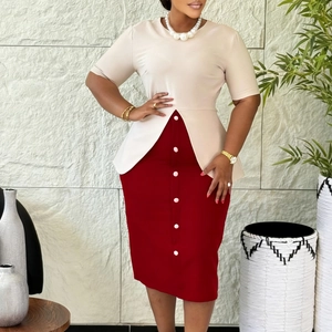 Détail d'une robe bicolore chic avec haut à basque beige et jupe crayon rouge à boutons