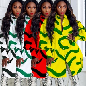Detail view of colorful printed button-up shirt dresses showing various vibrant patterns