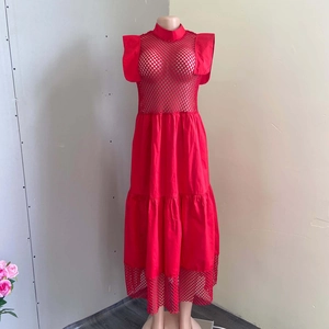 Détail d'une robe rouge à volants avec motifs évidés en maille et manches papillon sur mannequin